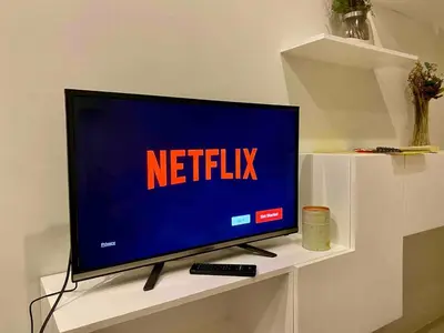 a television on a shelf with the netflix sign on it at Affordable Nordic Style Condo in Makati in Manila