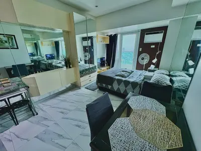 a room with a bed and a table and chairs at Cozy Condo at MakatiCBD in Manila