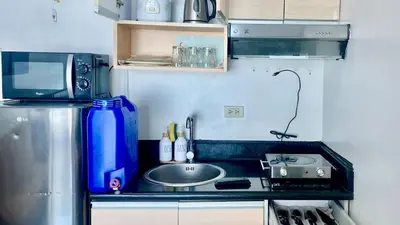 a small kitchen with a sink and a microwave at High End Penthouse Makati CBD in Manila