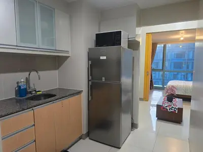 a kitchen with a stainless steel refrigerator and a sink at Beautiful Sunset One Uptown near Grand Hyatt BGC Uptown, St Lukes Medical Center, and Mitsukoshi Mall in Manila