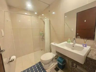 a bathroom with a sink and a toilet and a shower at Beautiful Sunset One Uptown near Grand Hyatt BGC Uptown, St Lukes Medical Center, and Mitsukoshi Mall in Manila