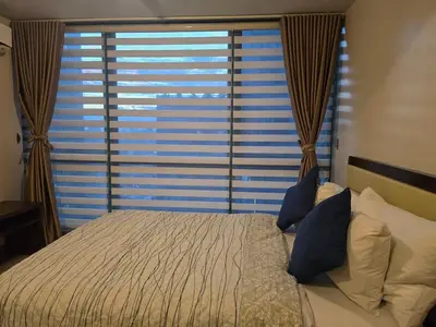 a bedroom with a bed and a large window at Beautiful Sunset One Uptown near Grand Hyatt BGC Uptown, St Lukes Medical Center, and Mitsukoshi Mall in Manila