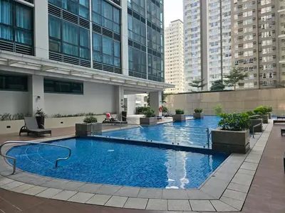 a large swimming pool in the middle of a building at Beautiful Sunset One Uptown near Grand Hyatt BGC Uptown, St Lukes Medical Center, and Mitsukoshi Mall in Manila