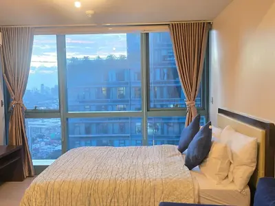 a bedroom with a bed and a large window at Beautiful Sunset One Uptown near Grand Hyatt BGC Uptown, St Lukes Medical Center, and Mitsukoshi Mall in Manila