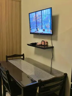 a table with a computer on a wall with a television at Cloud 1979 at Shore 2 Tower 2 in Manila