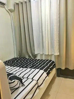 a bed in a room with a curtain at Cloud 1979 at Shore 2 Tower 2 in Manila