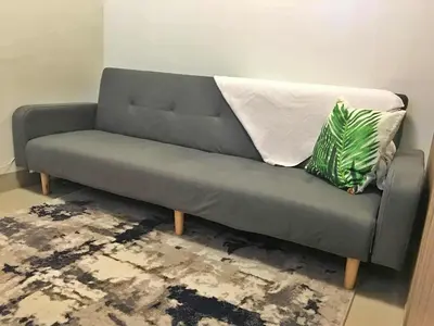 a gray couch with two pillows on it in a room at Cloud 1979 at Shore 2 Tower 2 in Manila