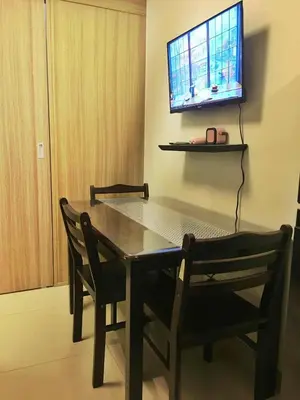 a dining room table with two chairs and a television on the wall at Cloud 1979 at Shore 2 Tower 2 in Manila