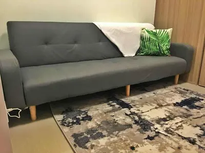 a gray couch in a living room with a rug at Cloud 1979 at Shore 2 Tower 2 in Manila