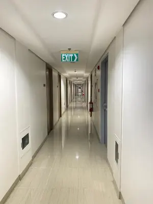 an empty hallway with an exit sign on the ceiling at Shore 2 tower 2 in Manila