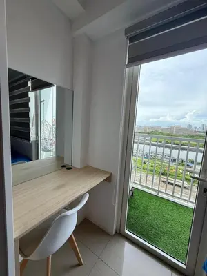 a room with a desk and a large window at Shore Residences in Manila