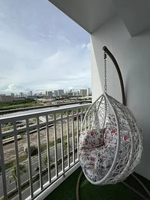 a swing on a balcony with a view of a river at Shore Residences in Manila