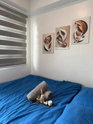 a bedroom with a blue bed with a tray on it at Shore Residences in Manila