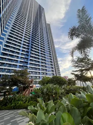 a tall building with a palm tree in front of it at City Comfort Staycation 1BR Air Residences Makati in Manila