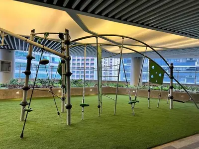 a playground with swings in a room with grass at City Comfort Staycation 1BR Air Residences Makati in Manila