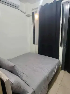 a small bed in a room with a black wall at Manial Mall of Asia 1 Bedroom Shore 2 Residence in Manila