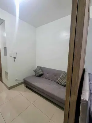a couch in a room with a white wall at Manial Mall of Asia 1 Bedroom Shore 2 Residence in Manila