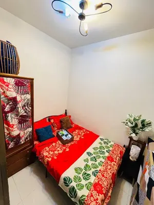 a bedroom with a bed with a red comforter at Staycation ni Gelo in Manila
