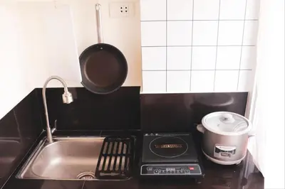 a kitchen with a sink and a pot on a stove at Cozy and Affordable Loft Condo in Manila Center in Manila