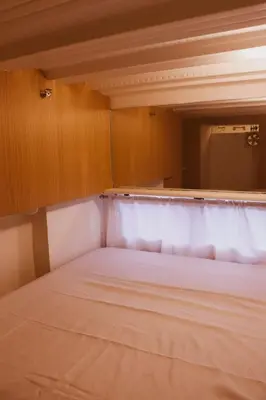 a bed in a small room with a cabinet at Cozy and Affordable Loft Condo in Manila Center in Manila