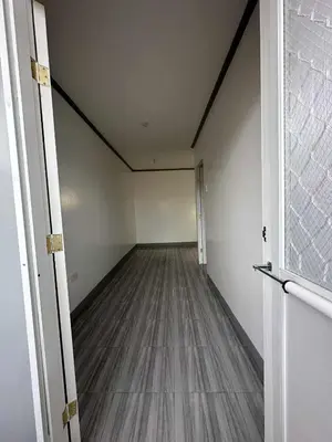 an empty room with a wooden floor and white walls at Diego Residences in Manila