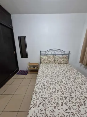 a bedroom with a bed with a bedspread on it at Stayscape at Kensington in Manila