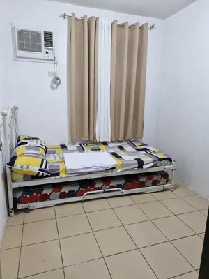 a bed in a room with a window at Stayscape at Kensington in Manila