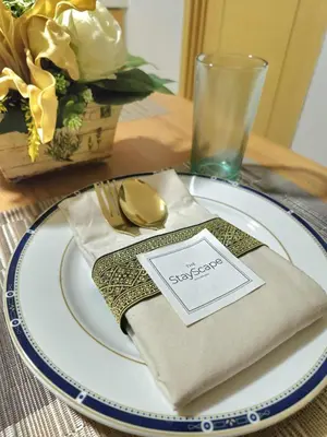 a table with a plate with a fork and a napkin at Stayscape at Kensington in Manila