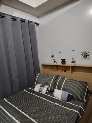 a bed in a room with black curtains at AteAbyPlace648 in Manila