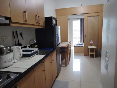 a kitchen with wooden cabinets and a counter top at AteAbyPlace648 in Manila