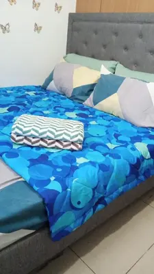 a bed with a blue comforter and pillows at AteAbyPlace648 in Manila