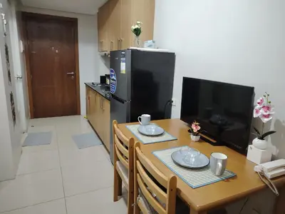 a kitchen with a table and a television and a table and chairs at AteAbyPlace648 in Manila