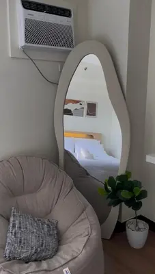 a room with a bed and a chair and a mirror at The Camden Place in Manila
