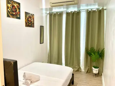 a room with a bed and a window with curtains at MG Labels Property in Manila