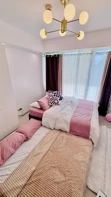 a bedroom with two beds and a chandelier at MG Labels Property in Manila