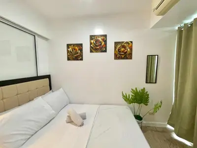 a bedroom with a bed with three paintings on the wall at MG Labels Property in Manila