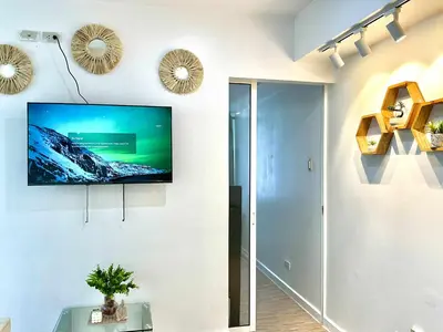 a living room with a flat screen tv on a wall at MG Labels Property in Manila