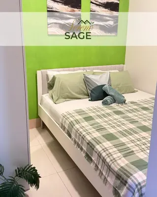 a bedroom with a bed with a green wall at Serene Sage in Manila