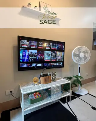 a living room with a tv on a wall at Serene Sage in Manila