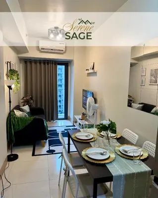 a dining room with a table and chairs in a living room at Serene Sage in Manila