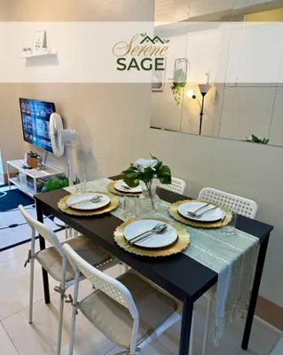 a dining room table with chairs and a black table at Serene Sage in Manila