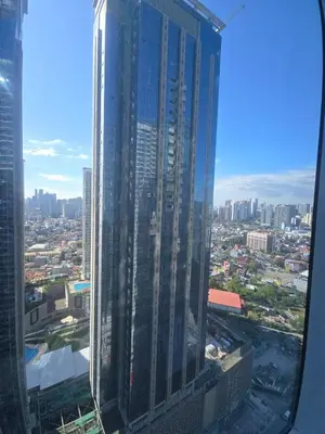a view of a city from the window of a skyscraper at Uptown Parksuites BGC Cosy Hotel Vibe Flat near St Lukes, Uptown Mall, Mitsukoshi and Grand Hyatt in Manila