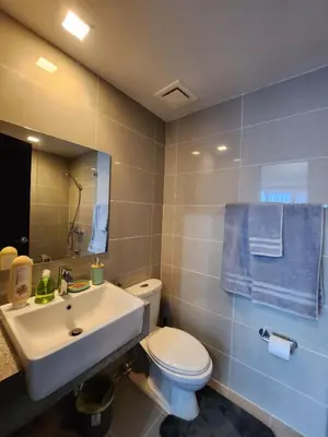 a bathroom with a sink and a toilet and a mirror at Uptown Parksuites BGC Cosy Hotel Vibe Flat near St Lukes, Uptown Mall, Mitsukoshi and Grand Hyatt in Manila