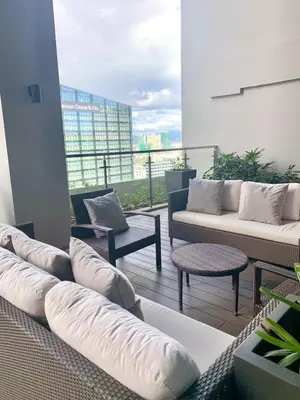 a living room with couches and chairs on a balcony at Uptown Parksuites BGC Cosy Hotel Vibe Flat near St Lukes, Uptown Mall, Mitsukoshi and Grand Hyatt in Manila