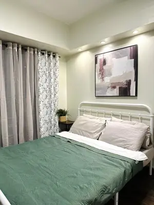 a bedroom with a bed and a painting on the wall at NEW 2-Bedroom 2-Bath Condo - Flair Towers, near Greenfield District, Ortigas in Manila