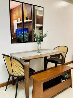 a dining room table with chairs and a vase on it at NEW 2-Bedroom 2-Bath Condo - Flair Towers, near Greenfield District, Ortigas in Manila