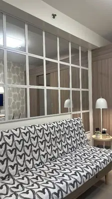 a bedroom with a large bed and a large mirror at CozyCalmStaycation in Manila