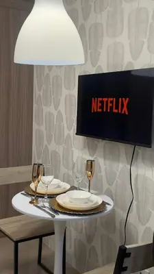 a table with wine glasses and a sign on a wall at CozyCalmStaycation in Manila