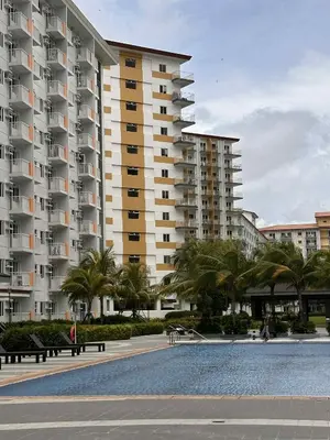 a large building with palm trees and a swimming pool at EuEL Condo in Manila