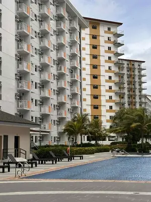 a large apartment building with benches in front of a pool at EuEL Condo in Manila